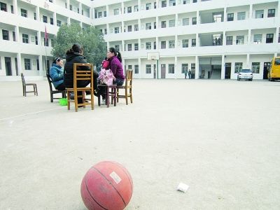 几名老师坐在空荡荡的操场上闲聊。记者杨佳峰 摄