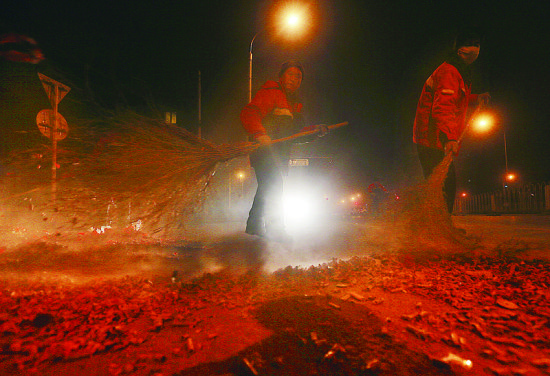 今天凌晨一点，环卫工人在首都博物馆附近的街道清扫爆竹皮 摄/记者柴程